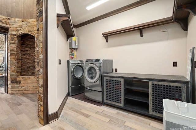 laundry room with crown molding, light wood-type flooring, and washer and clothes dryer