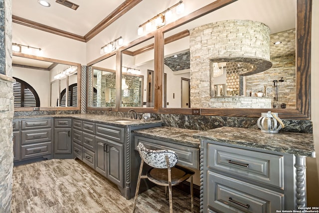 bathroom with hardwood / wood-style flooring, ornamental molding, and vanity