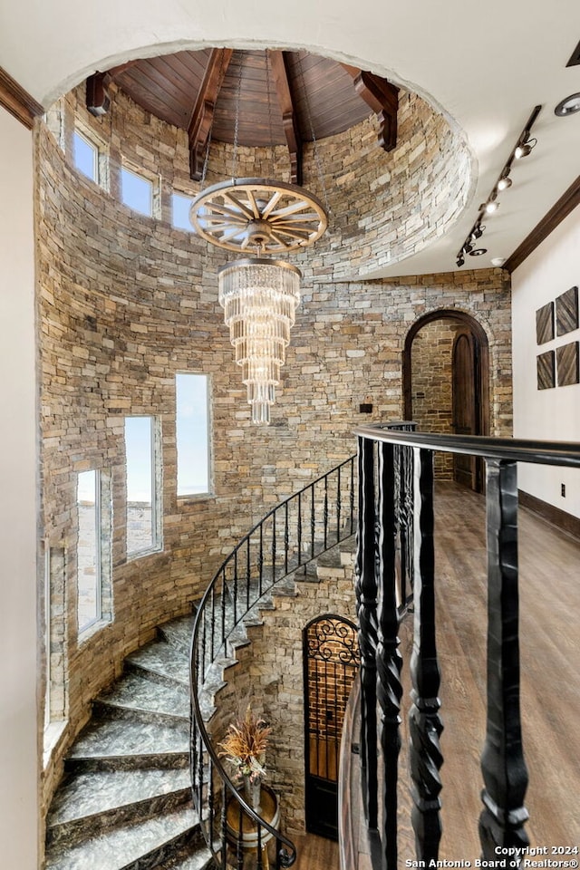 stairs with wood ceiling, an inviting chandelier, track lighting, and hardwood / wood-style flooring