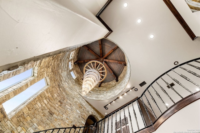 stairs with a skylight and a high ceiling