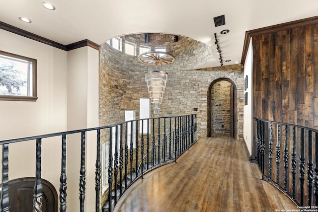 corridor featuring ornamental molding and wood-type flooring