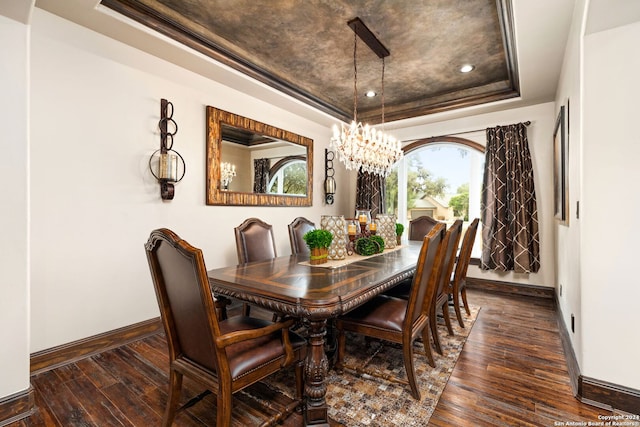 dining room featuring dark hardwood / wood-style flooring, a chandelier, and a raised ceiling