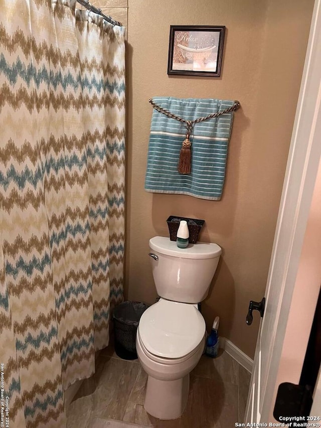 bathroom with toilet and tile floors