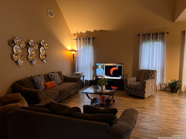 living room with high vaulted ceiling and hardwood / wood-style flooring