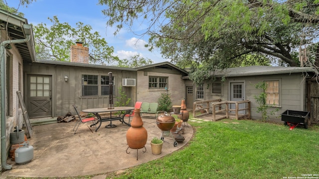 rear view of property featuring a patio area, a yard, and an AC wall unit