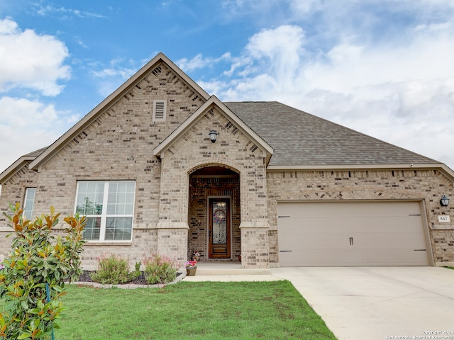 view of front of house with a garage and a front lawn