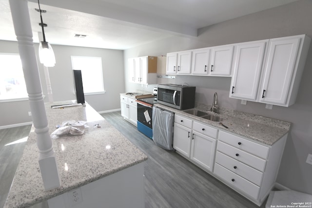 kitchen featuring light stone counters, decorative light fixtures, sink, and white cabinets