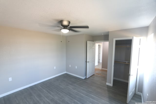 unfurnished bedroom with a closet, ceiling fan, dark hardwood / wood-style floors, and a textured ceiling