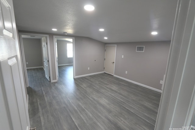 basement with a textured ceiling and dark wood-type flooring