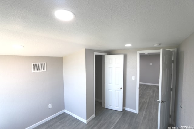 unfurnished bedroom with dark wood-type flooring and a textured ceiling