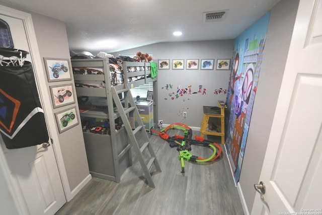 bedroom featuring lofted ceiling and hardwood / wood-style floors