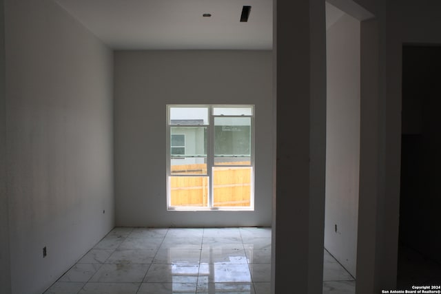 spare room featuring marble finish floor