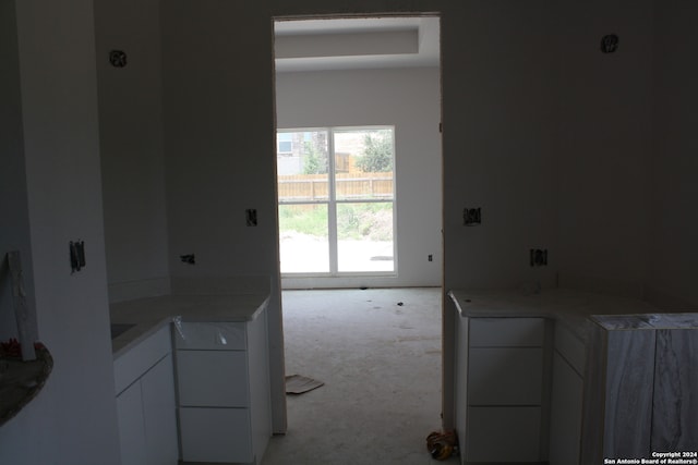 kitchen with light countertops, modern cabinets, white cabinetry, and light colored carpet