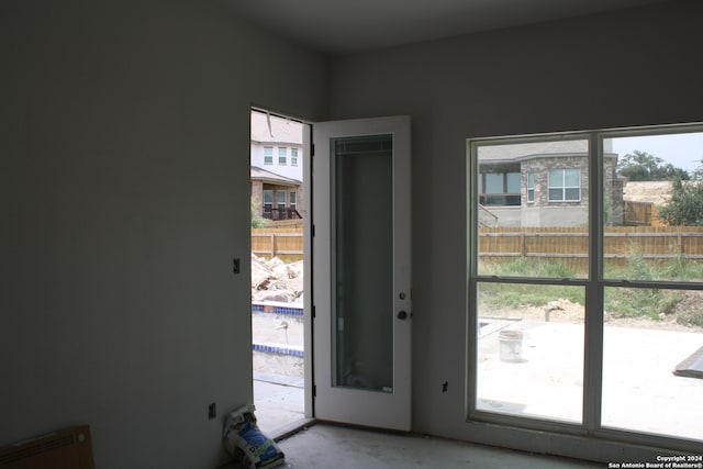 doorway with a healthy amount of sunlight and unfinished concrete flooring