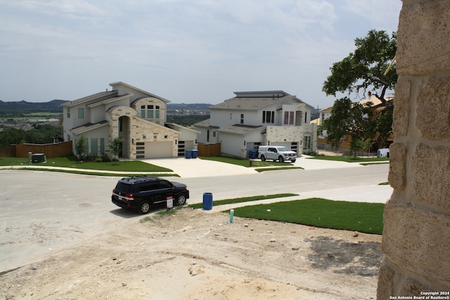 view of yard featuring a garage, a residential view, and concrete driveway