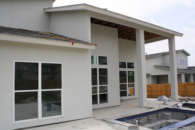 exterior space featuring a patio area, fence, a fenced in pool, and stucco siding