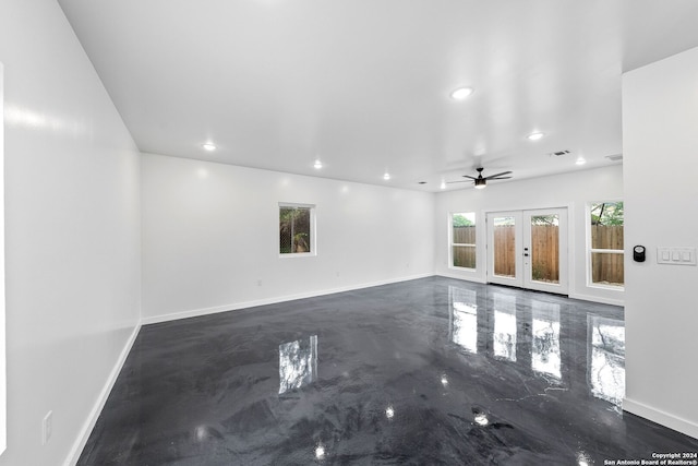 unfurnished living room with french doors, ceiling fan, and concrete flooring