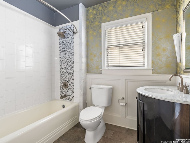 full bathroom with tile flooring, tiled shower / bath, vanity, and toilet