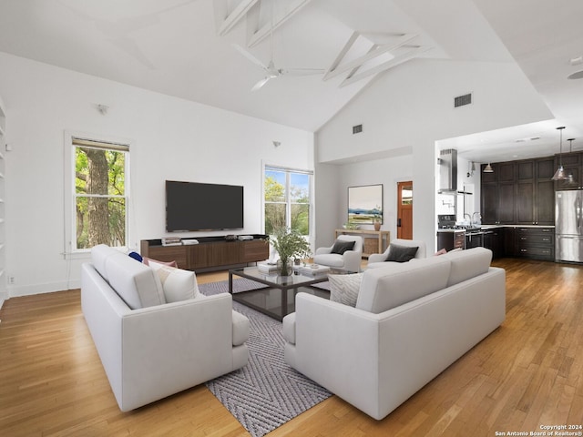 living room featuring high vaulted ceiling, ceiling fan, and light hardwood / wood-style flooring