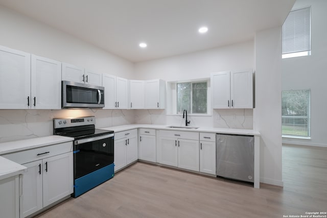 kitchen featuring sink, light hardwood / wood-style floors, stainless steel appliances, and plenty of natural light