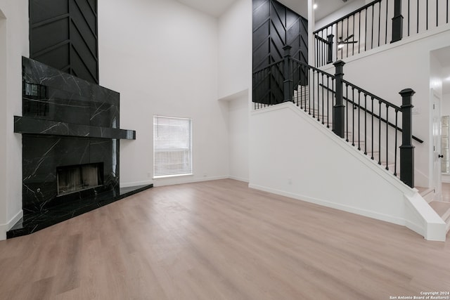 living room with a fireplace, hardwood / wood-style flooring, and a high ceiling