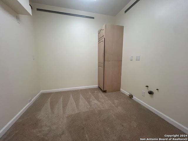 unfurnished room featuring light carpet