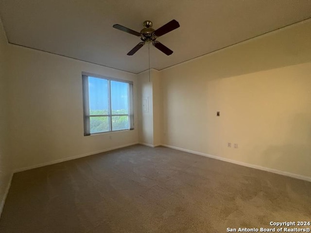 carpeted spare room with ceiling fan