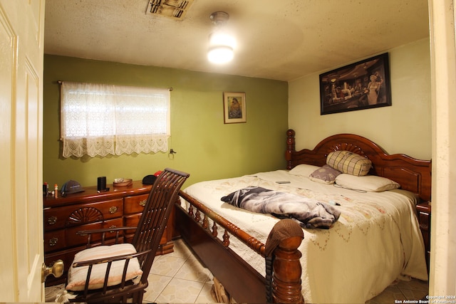 bedroom featuring a textured ceiling and light tile floors