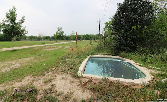 view of swimming pool with a yard