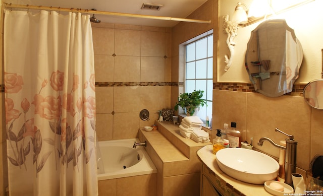 bathroom featuring vanity and tile walls