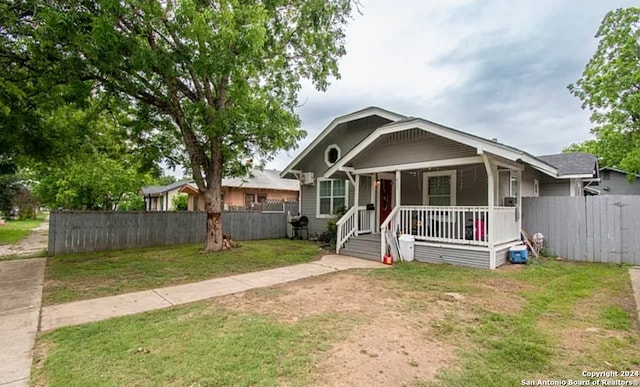 bungalow with a porch and a front lawn