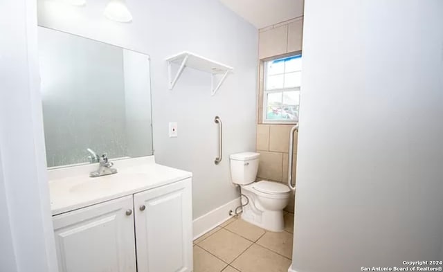 bathroom featuring toilet, tile flooring, and vanity