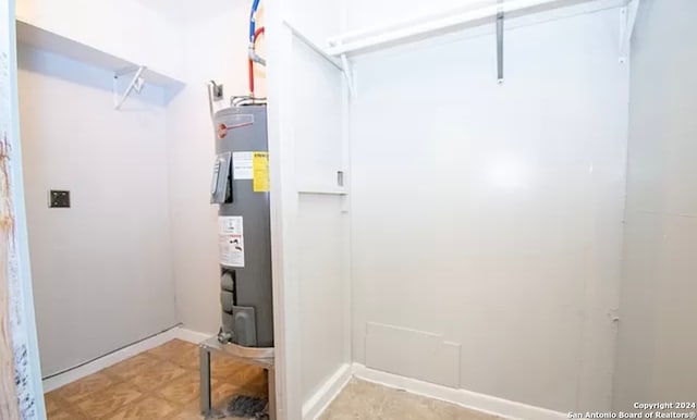 washroom featuring water heater and light tile flooring