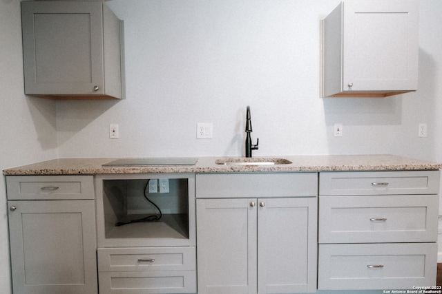 kitchen with sink and light stone counters