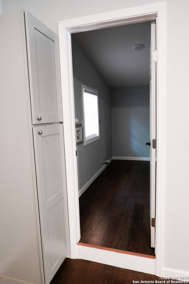 hall featuring dark hardwood / wood-style flooring and vaulted ceiling