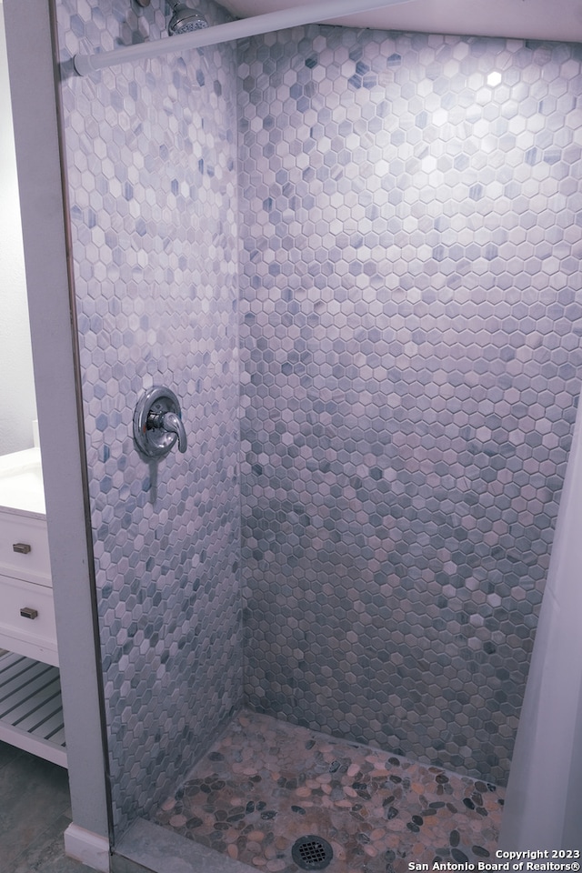 bathroom with vanity and tiled shower