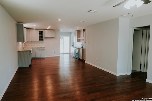 unfurnished living room featuring ceiling fan, dark hardwood / wood-style floors, and sink