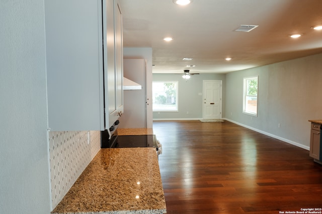 living room featuring dark hardwood / wood-style floors, a wealth of natural light, and ceiling fan