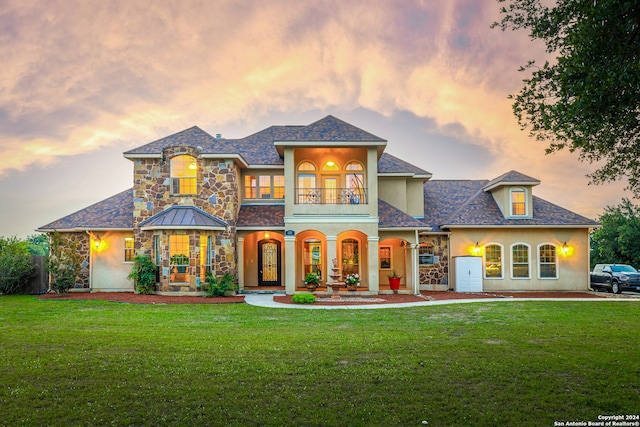 view of front of house featuring a yard and a balcony