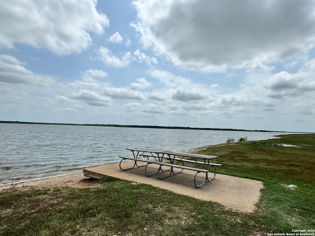 dock area featuring a lawn and a water view