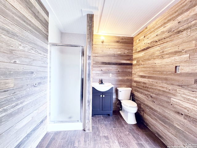 bathroom featuring an enclosed shower, vanity, toilet, and wooden walls