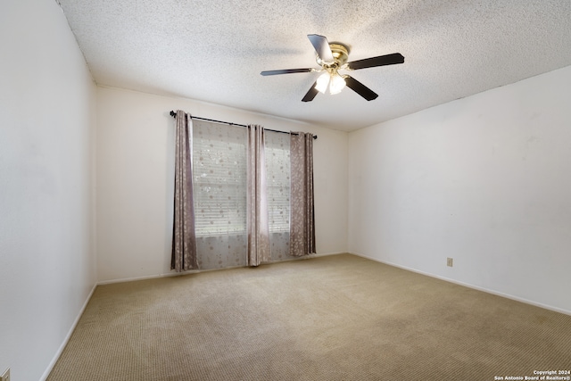 unfurnished room featuring ceiling fan, carpet, and a textured ceiling