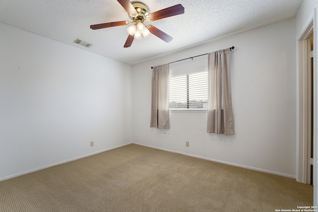 carpeted spare room featuring a textured ceiling and ceiling fan