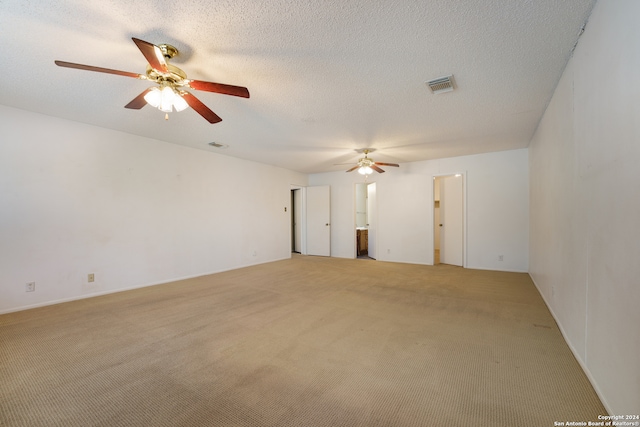 spare room featuring light carpet, a textured ceiling, and ceiling fan