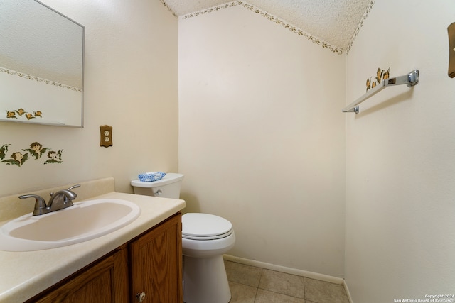 bathroom featuring toilet, tile patterned flooring, vanity, a textured ceiling, and vaulted ceiling