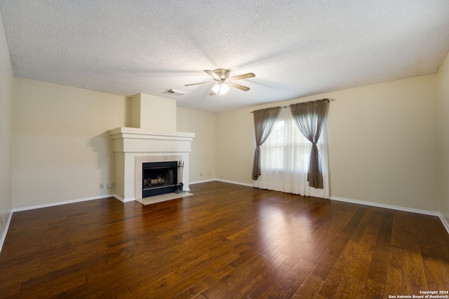 unfurnished living room with ceiling fan, dark hardwood / wood-style floors, and a textured ceiling