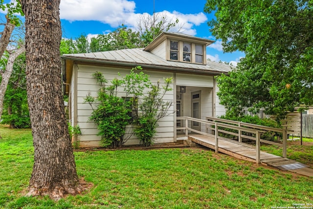 view of front of home featuring a front lawn and a wooden deck