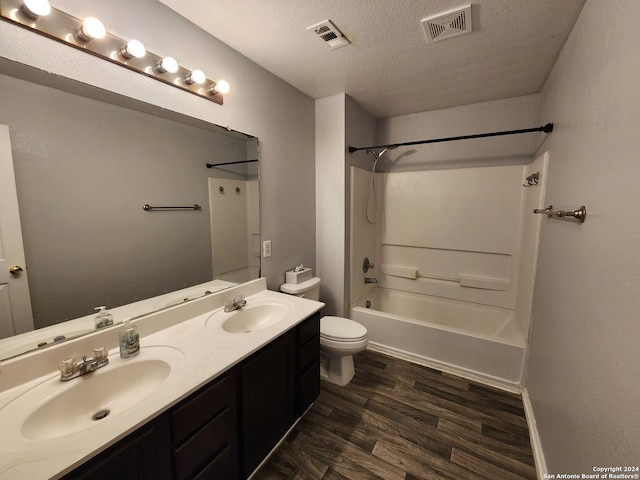 full bathroom with vanity, a textured ceiling, shower / washtub combination, wood-type flooring, and toilet