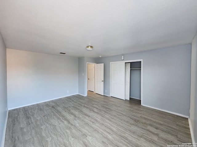 unfurnished bedroom featuring a textured ceiling and hardwood / wood-style flooring