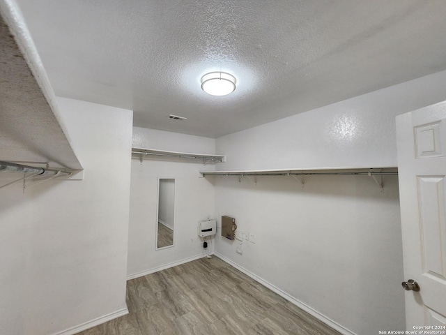 laundry area featuring light hardwood / wood-style floors and a textured ceiling